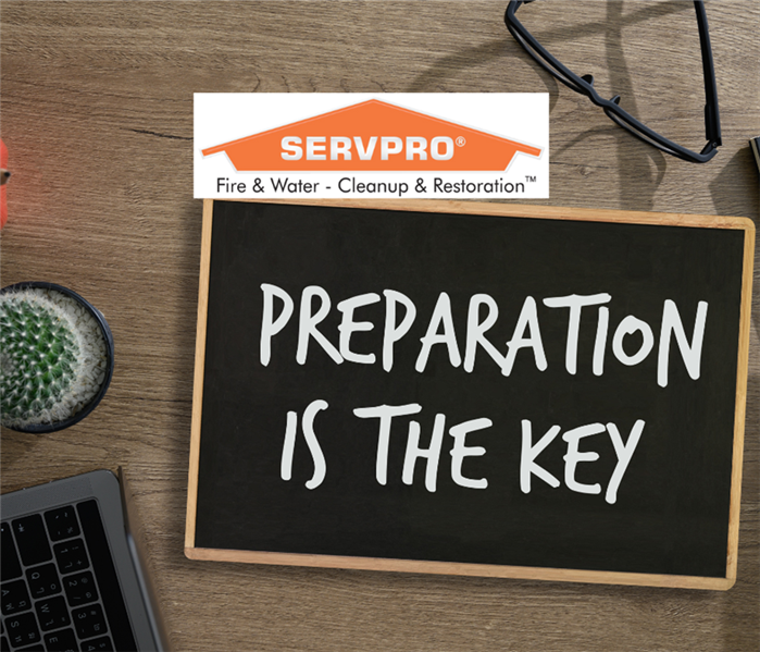 Blackboard stating "Preparation is the Key" lying on a work station.
